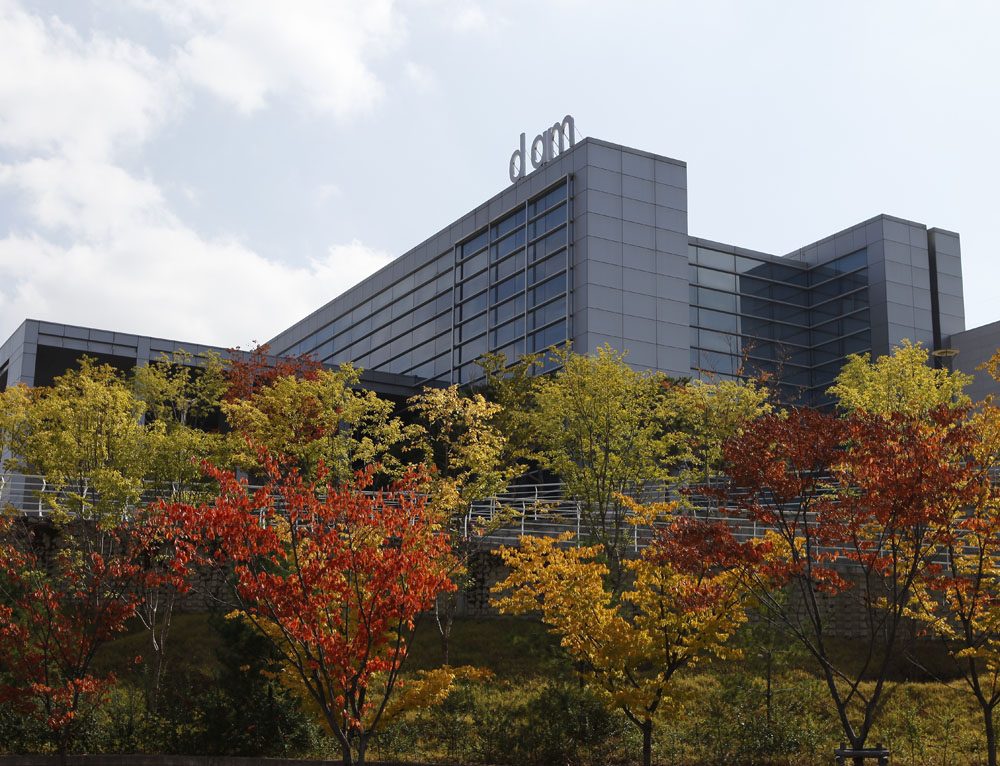 가을 단풍 나무 위로 'dam' 글자가 올려진 유리 창 건물, 대구미술관